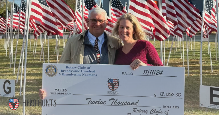 Hero Hunts Team Member poses with the donation check and a representative from the Rotary Clubs